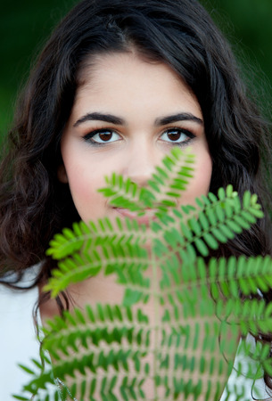 Beautiful brunette girl relaxing in the park wiht many plants of backgroundの写真素材