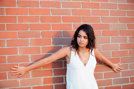 Happy beautiful brunette girl with red wall brick of backgroundの写真素材
