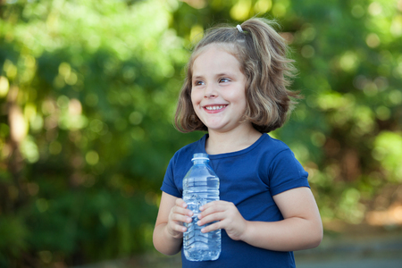 Cute little girl with water bottle in the parkの写真素材