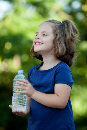 Cute little girl with water bottle in the parkの写真素材