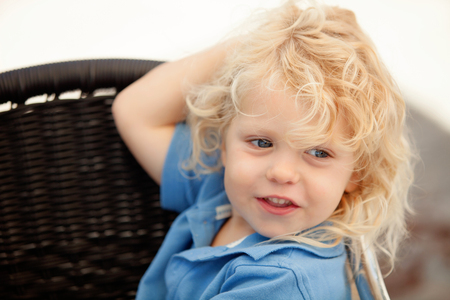 Beautiful boy three year old with long blond hair on a sunny dayの写真素材
