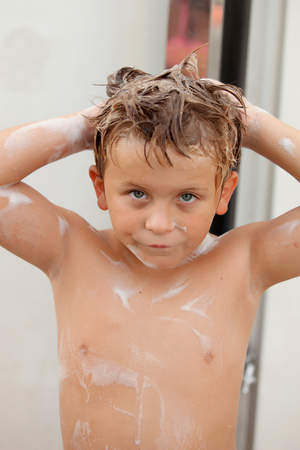 Funny kid showering in the yard for a summer afternoonの写真素材