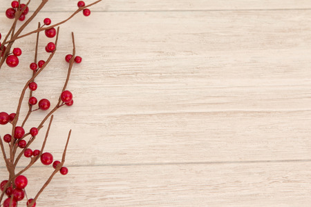 Christmas branch with red berries on a grey wooden backgroundの写真素材