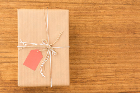 Nice gift wrapped with brown paper and decorated with white ribbons and red