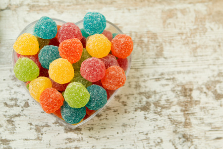 Sweet heart with jellybeans on a wooden backgroundの写真素材