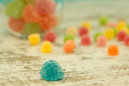 Colorful jelly beans on the wooden background. Focus on foregroundの写真素材