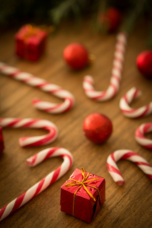 Candy canes with Christmas balls on a wooden backgroundの写真素材