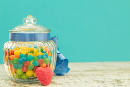 Nice glass container with blue ribbon filled candiesの写真素材
