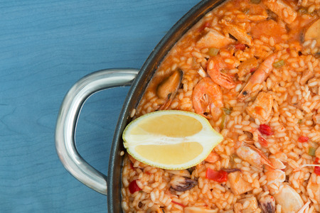 Spanish food. Seafood paella on a wooden blue backgroundの写真素材