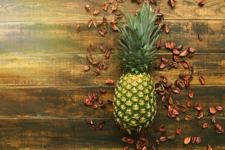 Green pinneaple on a rustic wooden tableの写真素材