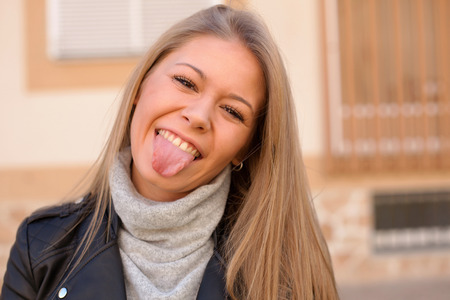 Happy beautiful young woman laughing and smiling on streetの写真素材