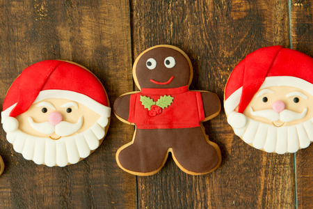Delicious Christmas cookies with Santa Claus face on a wooden tableの写真素材