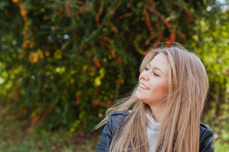 Pretty blonde girl with leather jacket in the street in a autumn dayの写真素材