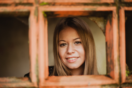 Pensive blonde woman next to a vintage windowsの写真素材