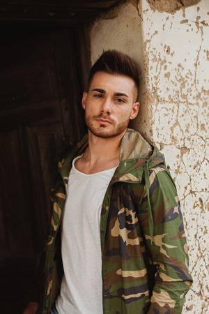 Atractive guy with jacket with military stylish in a vintage houseの写真素材