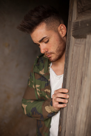 Atractive guy with jacket with military stylish in a vintage houseの写真素材