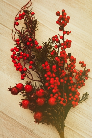 Red fruits on the branch Christmas for decoration on a wooden backgroundの写真素材