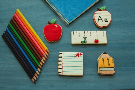 Tasty cookies with shape of school material on a blue wooden background