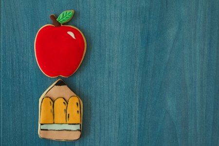 Two cookies with shape of a pencil and an apple on a wooden backgroundの写真素材