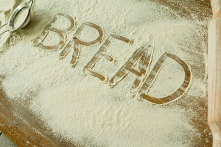 Flour on the table with writted word BREAD