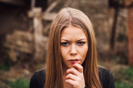 Beautiful blonde girl wih long hair and a sad expressionの写真素材