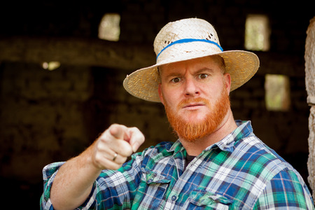 Red haired man with a straw hat in a rural enviromentの写真素材