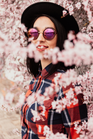 Brunette girl near a almond tree with many flowersの写真素材