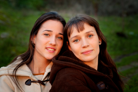 Nice sisters with blue eyes in a parkの写真素材