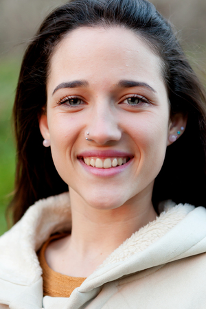 Smiling teen girl outside with a natural green of backgroundの写真素材