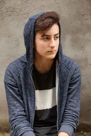 Serious teenager guy with hood on the headの写真素材