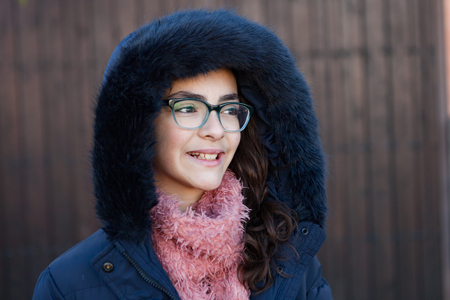 Smiling preteen girl wearing fur hood at winterの写真素材