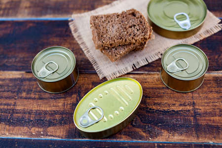 Cans of preserves on an aged wooden background