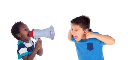 Funny little boy shouting through a megaphone to his friend. Isolated on white backgroundの写真素材
