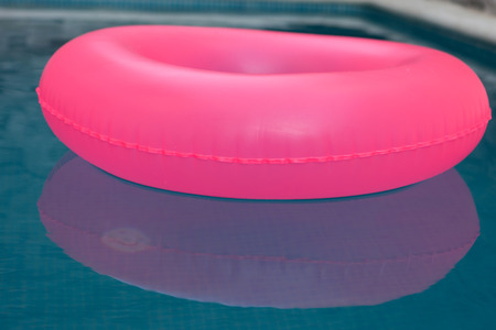 Pink float on a pool with crystal clear waterの写真素材