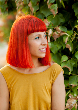 Pensive red haired woman in a park lit with a golden light