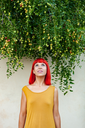 Red haired woman with yellow dress relaxed in a parkの写真素材