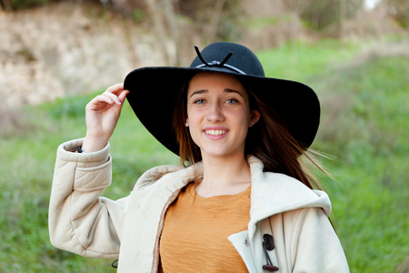 Stylish young woman with big hat in the fieldの写真素材
