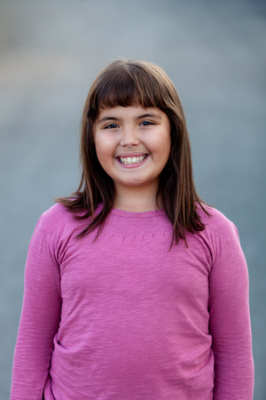 Little preteen girl with pink t-shirt in park
