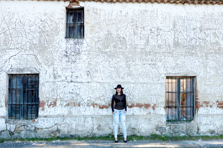Sensual woman with black cap in front of a vintage houseの写真素材