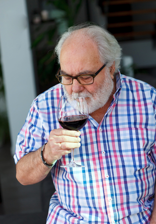 Mature man drinking wine at home