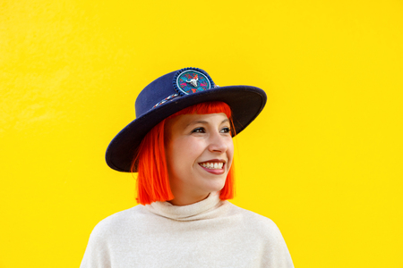 Attractive girl with a hat over a yellow wallの写真素材
