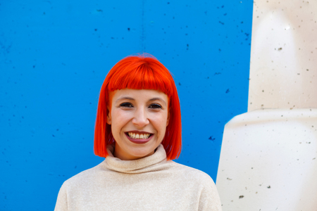 Attractive red hair girl with white jersey over a blue backgroundの写真素材