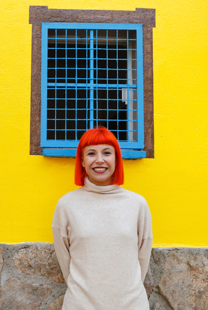 Attractive girl over a yellow house with funny windowsの写真素材