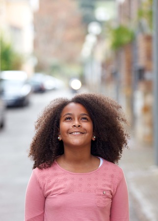 Cute African American girl smiling in the street with afro hairの写真素材