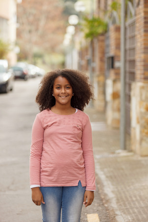 Cute African American girl smiling in the street with afro hairの写真素材