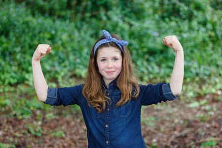 Strong girl with ten years old wearing a blue hair scarf enjoying of a beautiful day