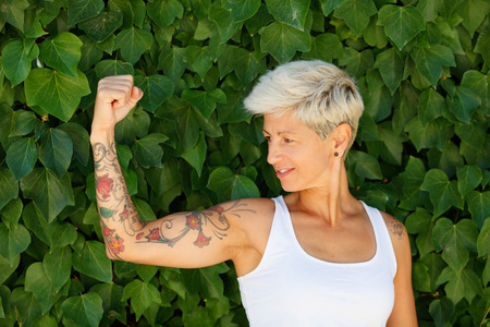 Blonde woman with flowered tattoos on her armの写真素材