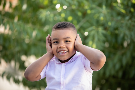 Small child covering his ears in a  beautiful parkの写真素材