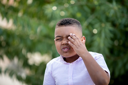 Happy child covering his eye in the parkの写真素材