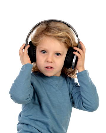 Happy blond child with headphones an blue t-shirt isolated on a white backgroundの写真素材